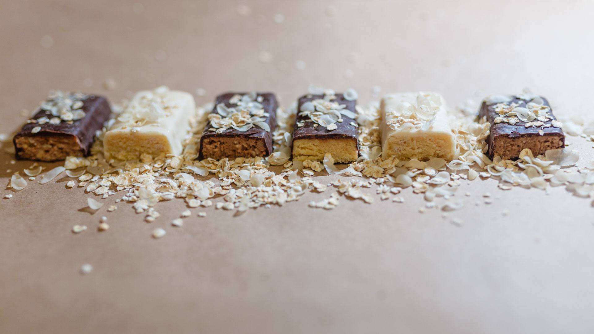 Six protein bars lay side by side. A good protein bar rule is to stay around 200-300 calories. 