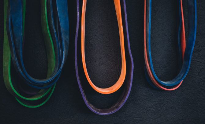 Resistance band exercises require resistance bands, of course. Here, three small piles of resistance bands lay on the floor, waiting to be used in a workout.