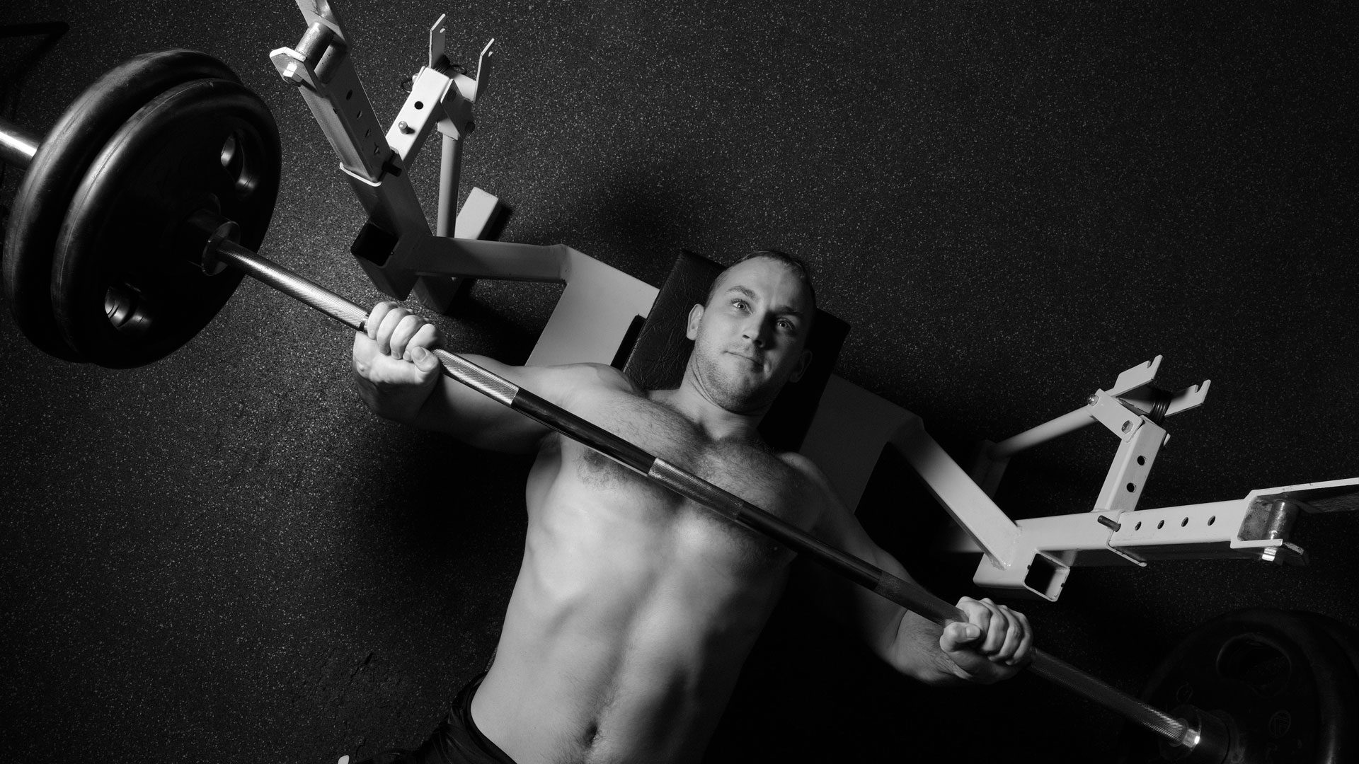 Weight lifting safety: A young man bench presses with no spotter. Looks cool, but highly unsafe. 