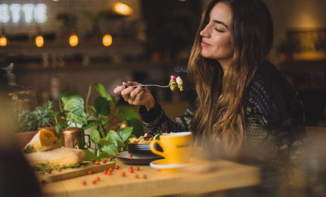 woman happily eating vegetables