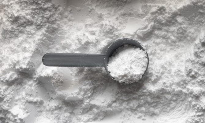 One scoop of white creatine monohydrate powder.