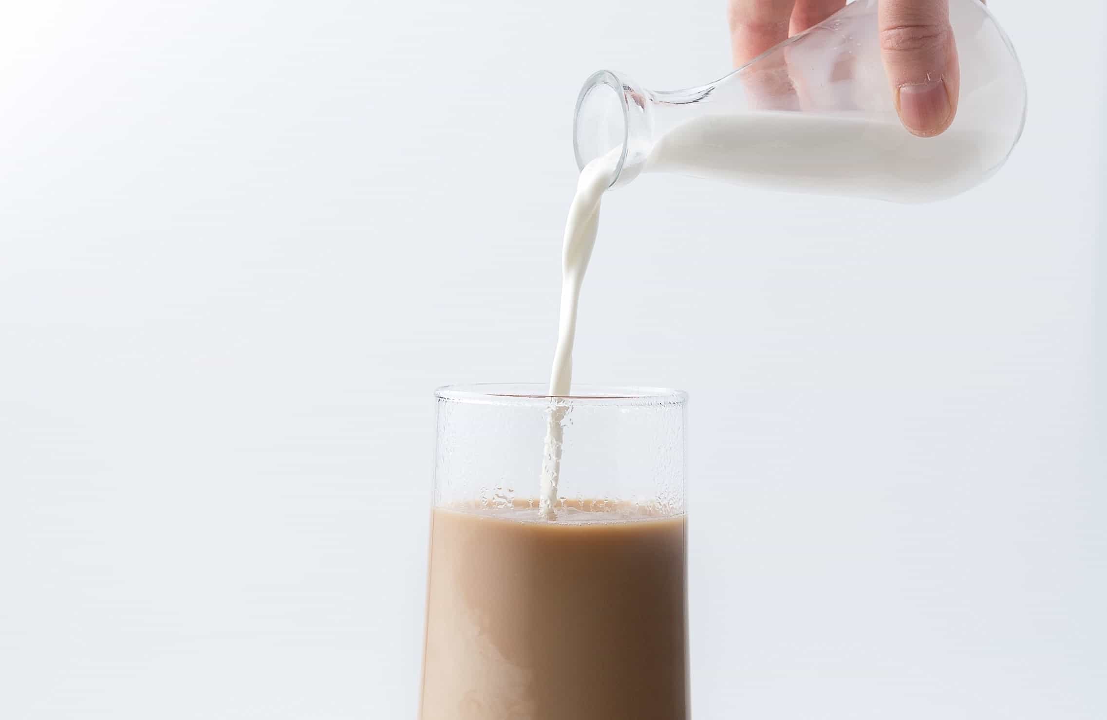milk being poured into coffee
