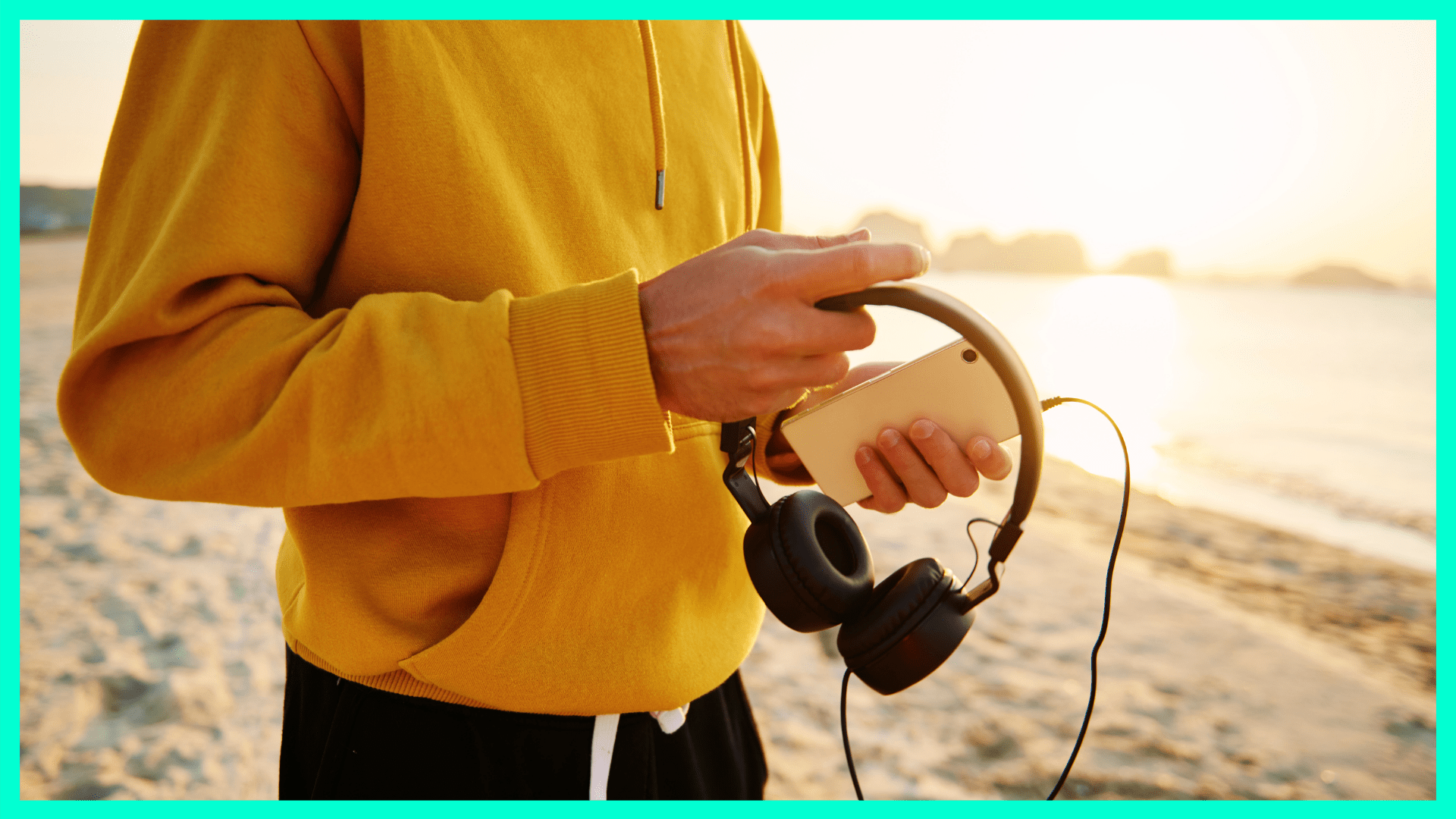 person holding headphones and an iphone