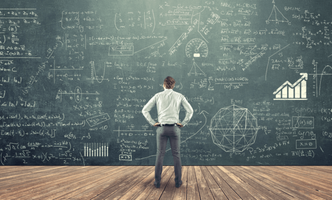 man looking at huge board of equations