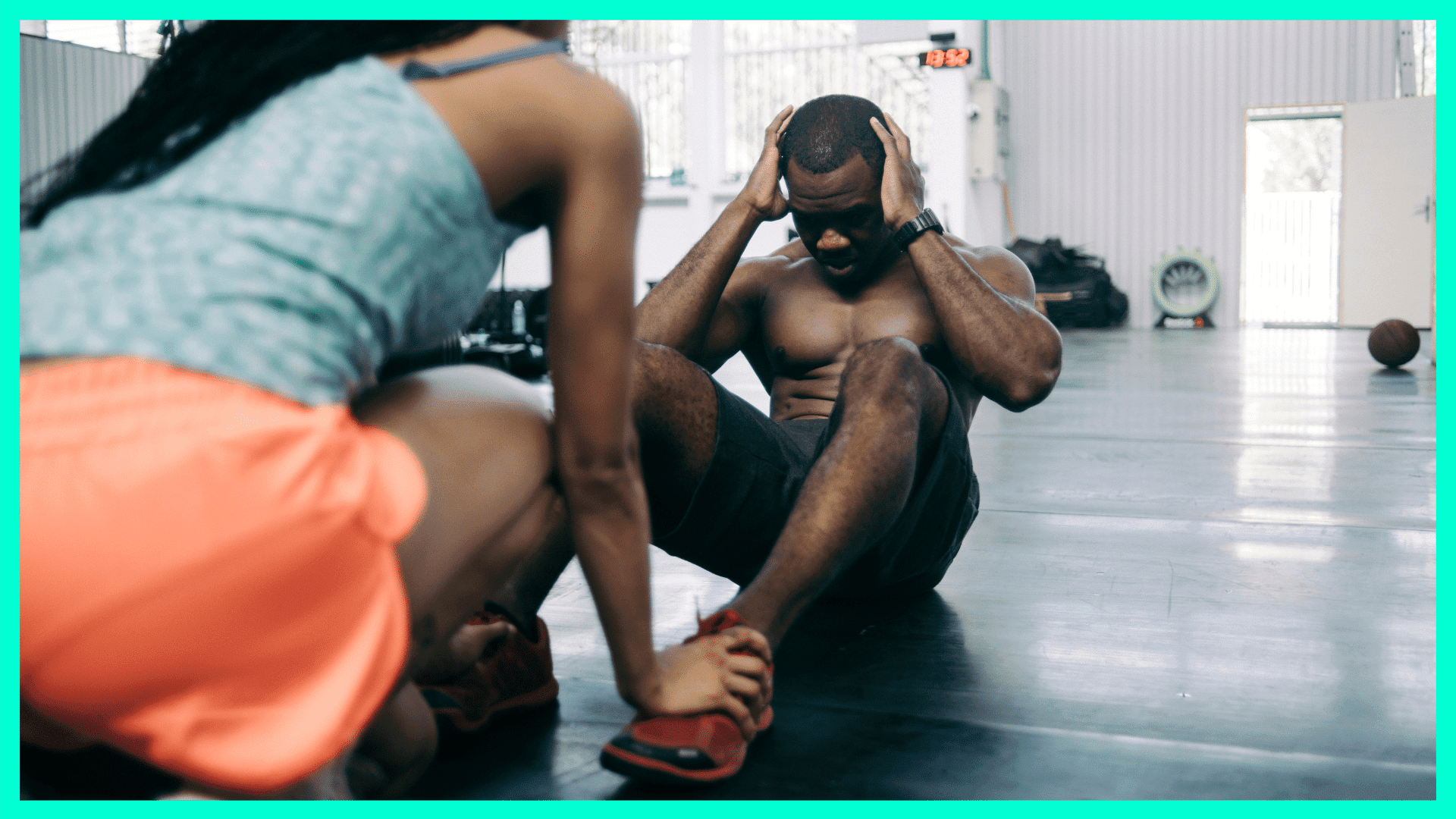 man doing crunches while woman holds his feet