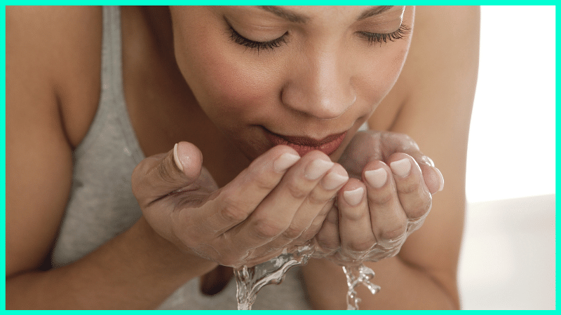 woman splashing water on face